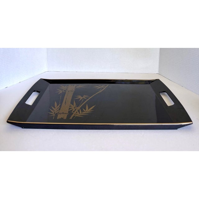Here is a vintage Marusei Japanese serving tray made of molded plastic with a glossy black finish and elegant gold bamboo...