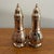 Pair of vintage silverplate salt and pepper shakers with embossed leaf bases, tapered necks, and pointed finial caps....