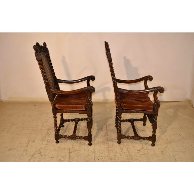 Pair of period Charles II oak arm chairs with exquisite hand carved decoration. The backs of the chairs have arched tops...