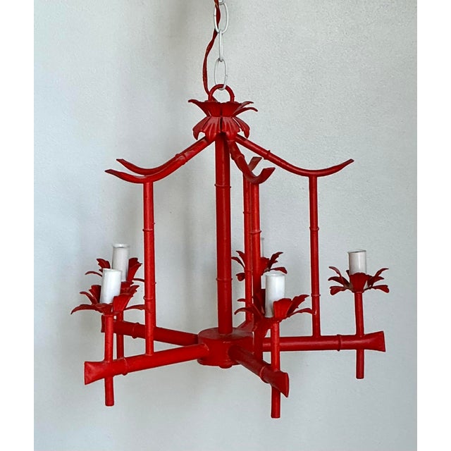 Chinoiserie flair. The vibrant, hand-painted red finish is accented by whimsical floral bobeches at each arm, creating a...