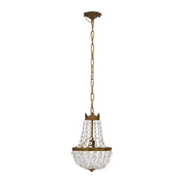 Antique chandelier from France made with cut crystal elements of cabochons and pendants. They are displayed on a brass...