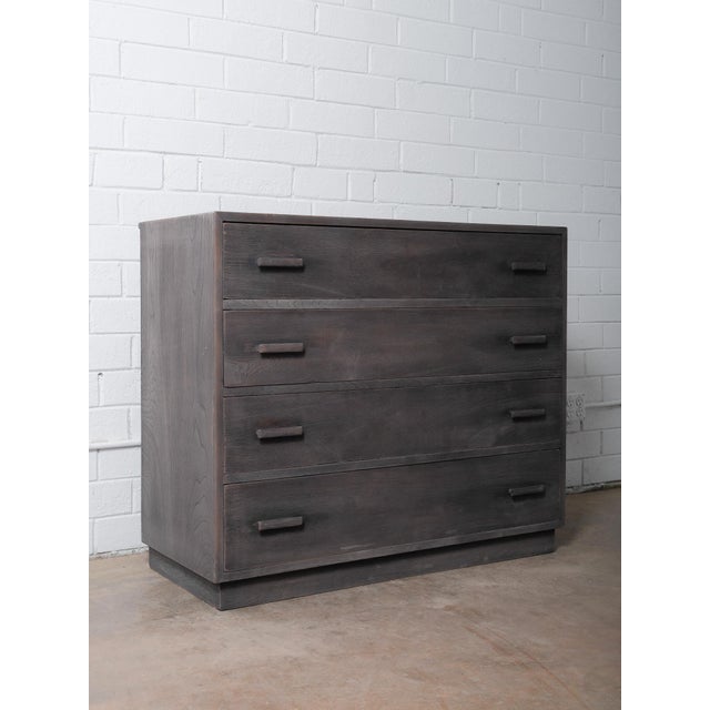 This charcoal finished wooden four-drawer dresser features a clean, timeless silhouette and a richly textured surface that...