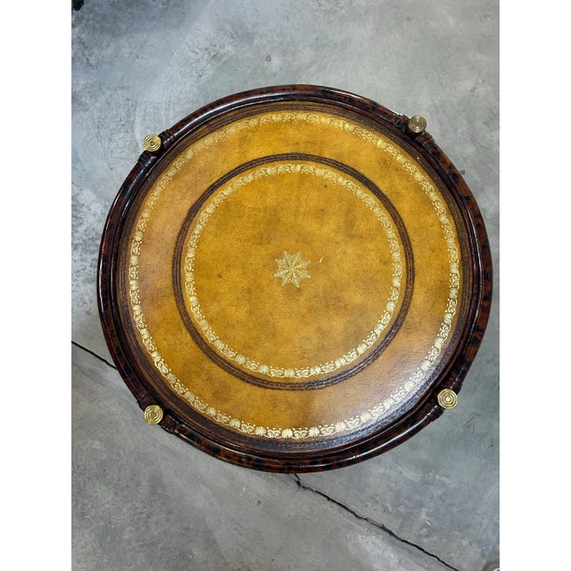 Elegant round two-tier side table by Maitland-Smith, handcrafted in the Philippines. This piece features a faux...