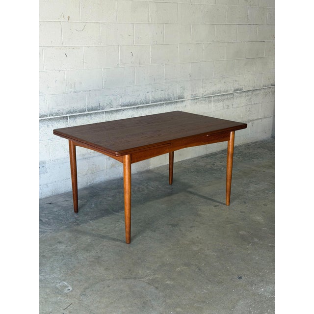 This elegant rectangular dining table expands effortlessly to accommodate extra guests. Slender tapered legs provide a...