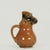 Whimsical antique glazed earthenware pitcher in the form of a smiling monkey. Marked Made in England on the bottom.