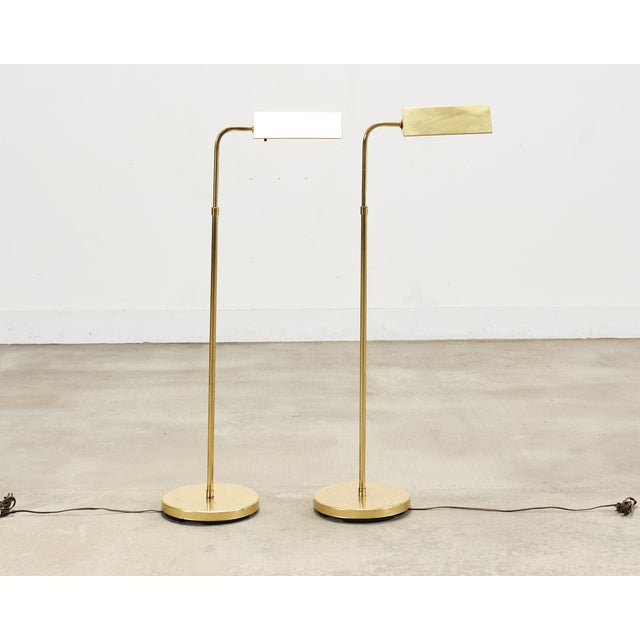 A refined matching pair of patinated mid-century modern brass pharmacy floor lamps made in the style of similar lamps by...