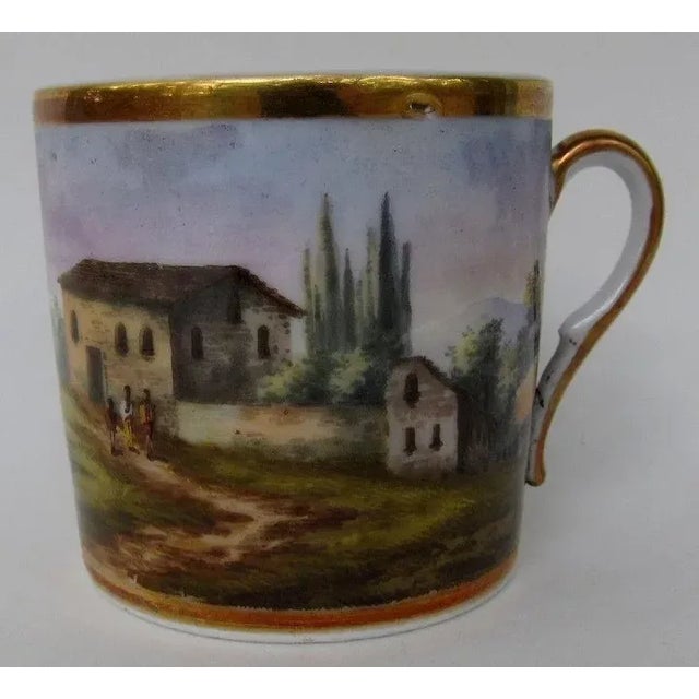 Antique 19th c. Paris porcelain coffee cup decorated with a continuous hand-painted landscape scene enhanced by rich...