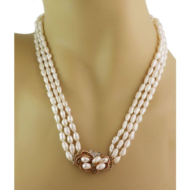 This beautiful vintage necklace features an ornate clasp crafted from 14k yellow gold in a fine wire vine and floral...