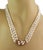 This beautiful vintage necklace features an ornate clasp crafted from 14k yellow gold in a fine wire vine and floral...