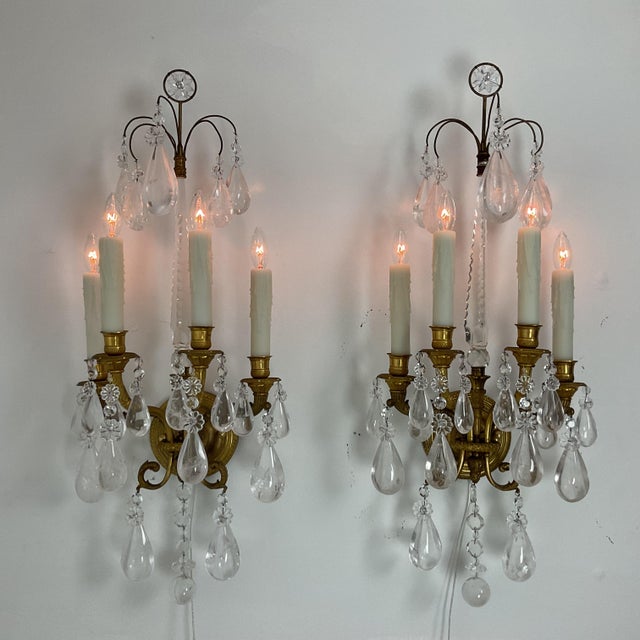 Elegant pair of Louis XVI-style gilt bronze and rock crystal wall sconces, featuring five candle-style lights arranged on...