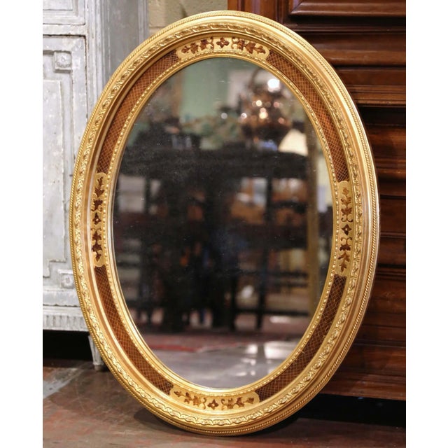 Elegant neoclassical detailing gives this vintage oval mirror a refined decorative presence. Crafted in France circa 1950,...