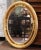 Elegant neoclassical detailing gives this vintage oval mirror a refined decorative presence. Crafted in France circa 1950,...
