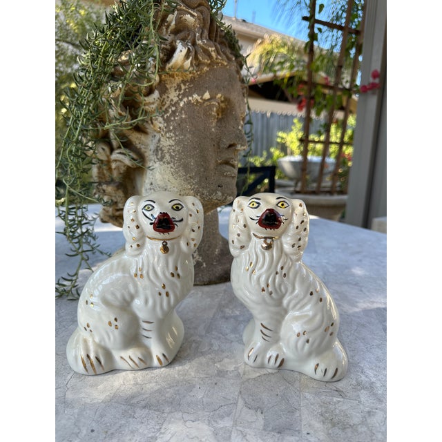 A charming pair of Staffordshire-style porcelain spaniel figurines featuring expressive faces, flowing coats, and hand-...