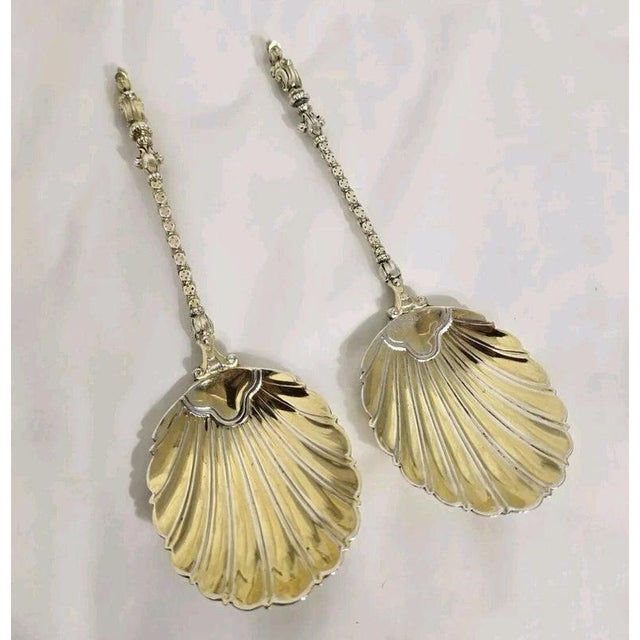 A fine pair of Victorian sterling silver and gilt serving spoons dating to 1887, beautifully designed for serving berries,...