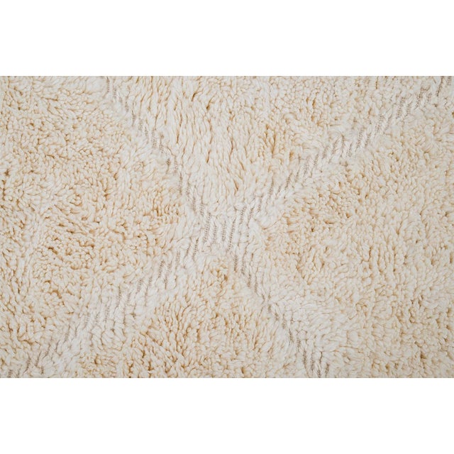 Modern hand-knotted wool rug showcasing a classic diamond lattice pattern in warm Ivory tones. Soft and durable, it adds a...