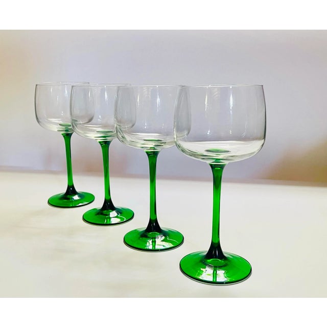 An elegant set of late 20th century stemware which presents a crisp aesthetic with its fresh green stem and slightly...