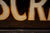 Early 20th-century pharmacy sign featuring reverse-painted "PRESCRIPTIONS" lettering in cream with gilt shadow detailing...