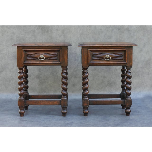 A handsome pair of early 20th-century french oak bedside cabinets in the louis xiii style. Each has a single drawer with...