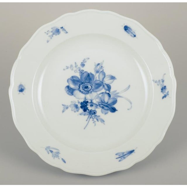 Meissen, Germany. Four dinner plates in porcelain. Hand-painted with floral motifs and insects in blue. Approximately...