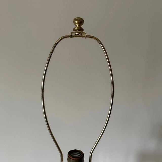 Cylindrical cut glass lamp body sits on a brass base. It is topped with a brass vase cap, neck, socket, turn knob and...