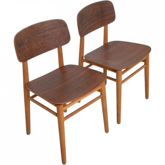 Set of two Hans Wegner FH4101 chairs with a wooden frame, consisting of a back and seat of teak and legs of beech. The...