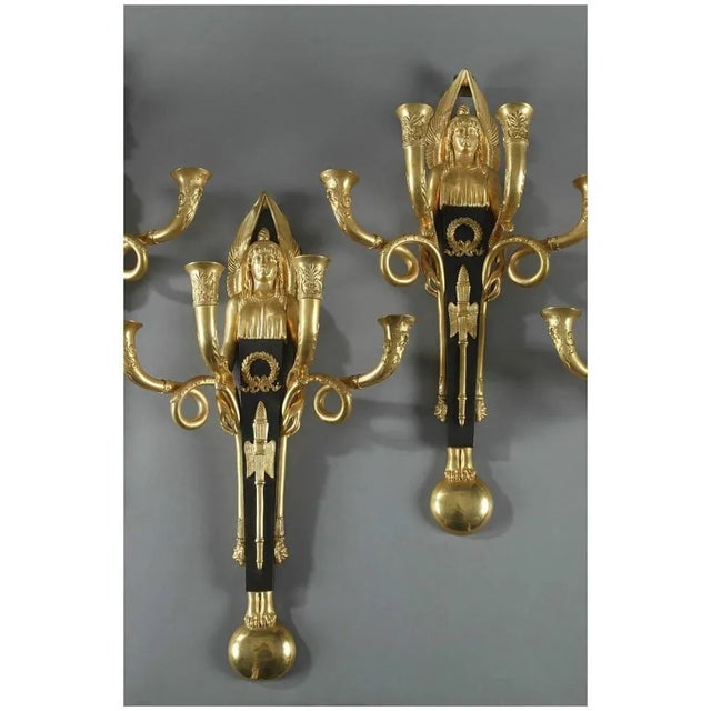 Pair of gilt and patinated bronze sconces from embellished with winged victories. Each sconce features four candlestick...