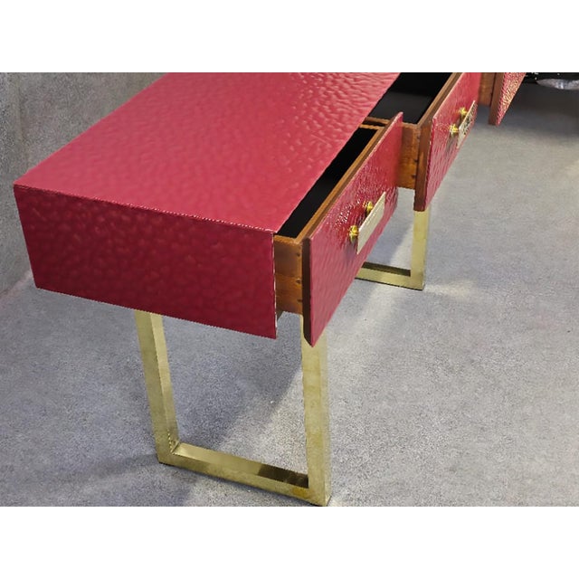 This refined Italian console table features a beautifully beveled red Murano glass top, complemented by three functional...