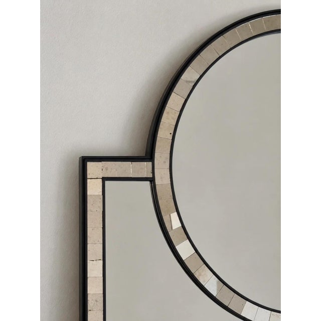 In excellent condition. This mirror features a black frame with segmented mirrored border panels and a circular upper...