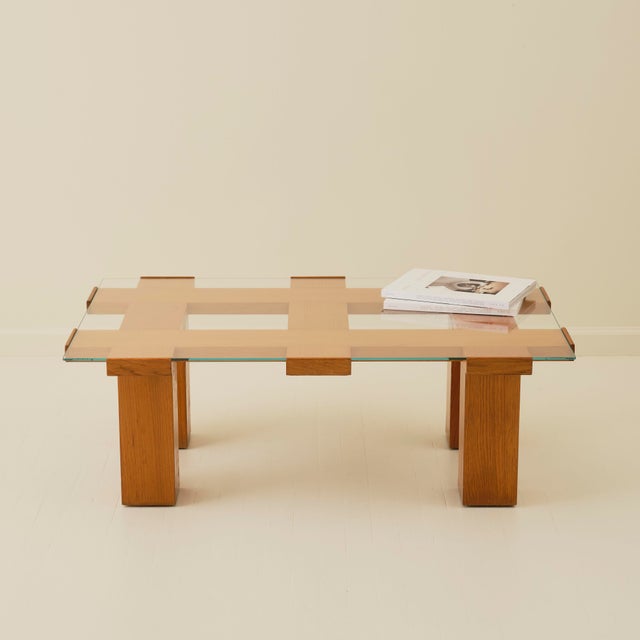 This striking Italian 1970s coffee table features a sculptural architectural wood base beneath a clear glass top. The...