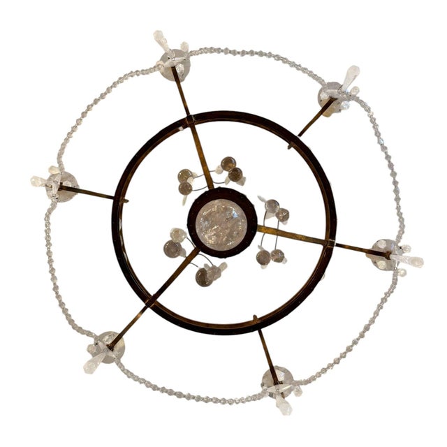 A highly decorative Italian Mid-20th-century chandelier in gold-leaf wrought iron, richly embellished with hand-carved...