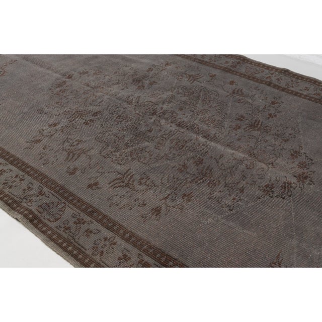 This is a vintage Turkish Oushak rug from the Mid 20th Century. The piece was hand-knotted.