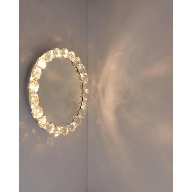 A beautiful round modernist wall mirror with a frame of huge diamond-shaped faceted crystals. Designed and executed by...