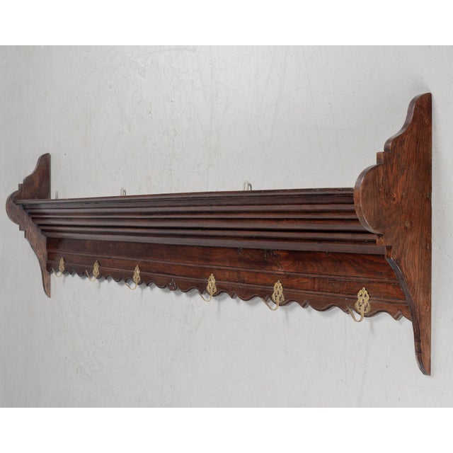 A French potière, or wall-mounted shelf made of solid oak with six cast brass hooks for hanging pots and pans in the...
