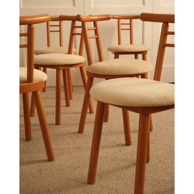 Set of six Italian wooden chairs featuring clean lines. Each wooden element is rounded at the ends, and the seat—also...