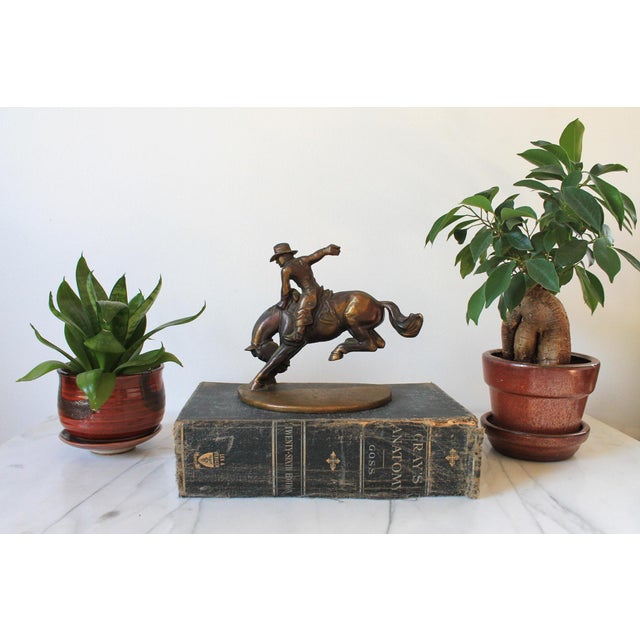 Single vintage bronze cowboy riding a horse bookend or doorstop. Made by Russwood. Dated 1946. Patina.