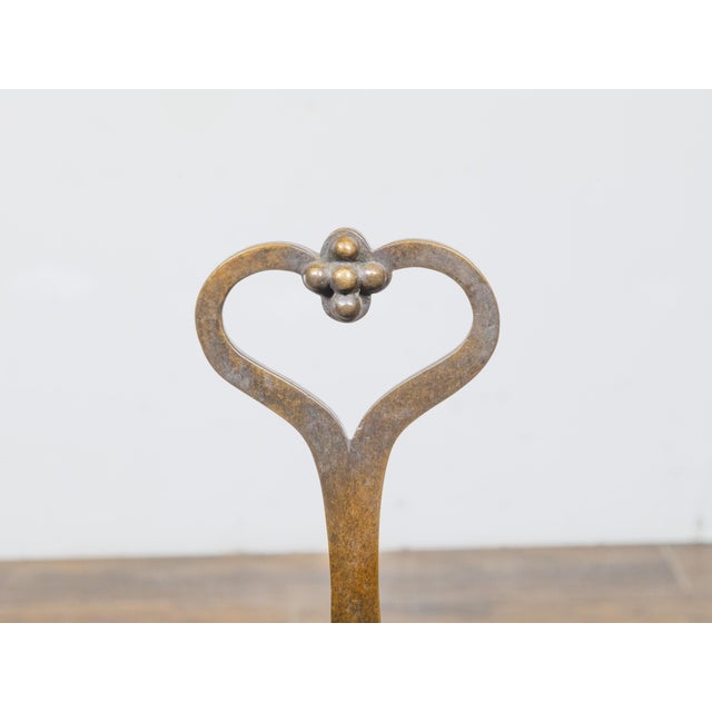 These elegant 19th-century English bronze andirons are a striking blend of functional design and decorative artistry....