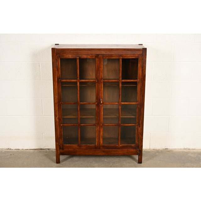 A beautiful antique Mission or Arts & Crafts period glass front two door bookcase or display cabinet In the manner of...