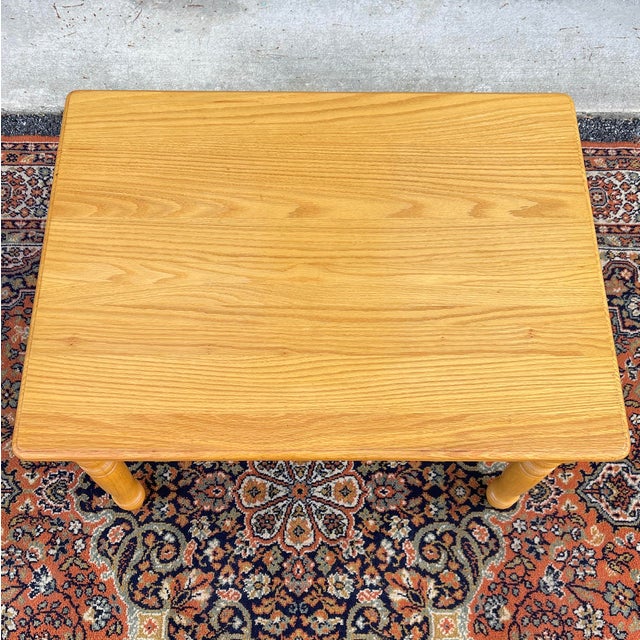 A vintage American Traditional oak child's playroom table having a natural oak finish, turned legs, and solid wood...