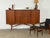 Mid-century sideboard in teak, dating from around the 1960s, with a long rectangular cabinet raised on sculpted legs...
