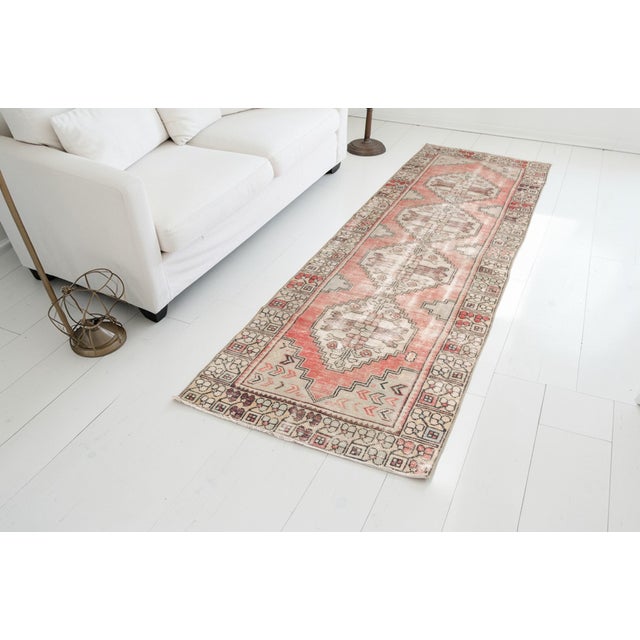 This is a vintage Turkish Oushak rug from the Mid 20th Century. The piece was hand-knotted.