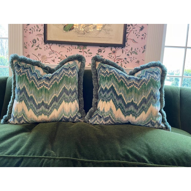 A pair of Schumacher pillows in blue and green flamestich fabric. Pillows were customized to add Samuel & Sons blue green...