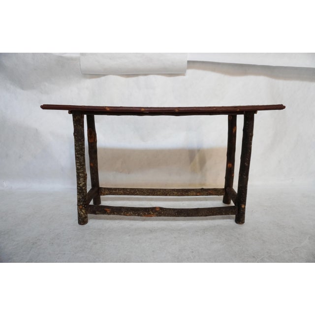 Wood and Twig Console Table The top surface of the table has narrow twig pieces (almost looks like bamboo) tightly bound...