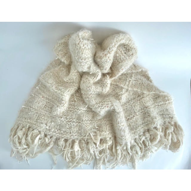 Luscious and loosely woven mohair throw incorporates multiple yarns with varying textures. Thick fringe adds another 7" to...