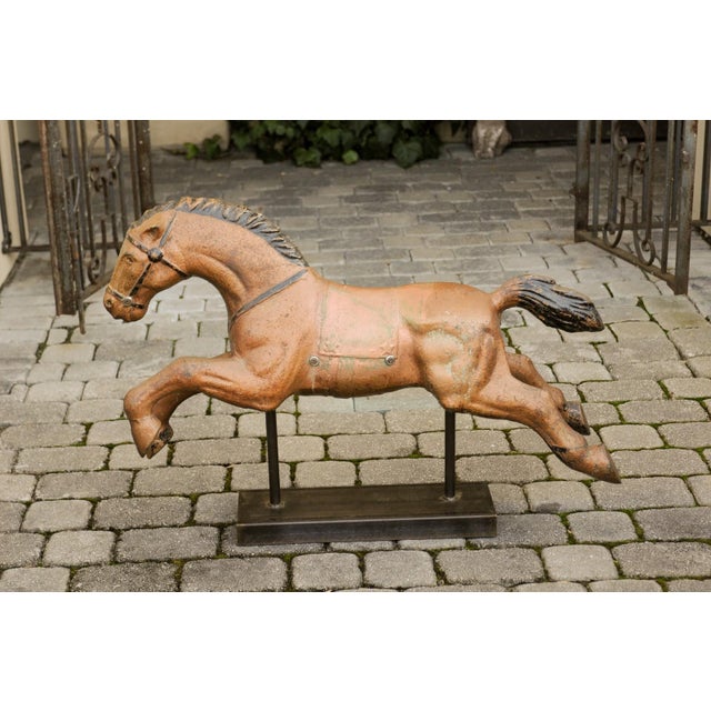 A vintage Folk Art painted iron old child riding horse from the mid-20th century mounted on a new custom base. Born in the...