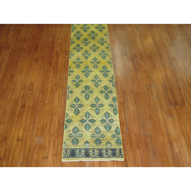 A borderless runner made from a large vintage Turkish runner in predominant shades in yellow and green. Measures: 2'6” x...