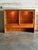 This elegant display piece showcases a minimalist silhouette with rounded top corners and sleek sliding glass doors. The...