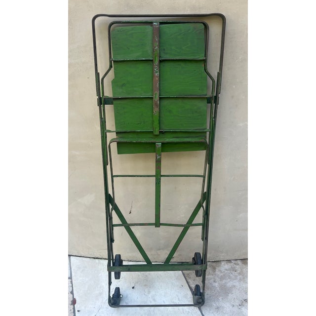 Folding vintage shopping cart made in the 1930's with original paint. The cart holds two baskets and is on castor wheels....