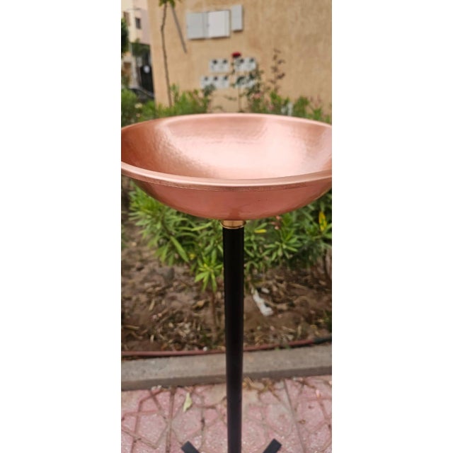 Bring timeless Moroccan craftsmanship to your outdoor space with this handcrafted hammered copper bird bath by Berbereino...