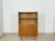 Elegant mid-century display cabinet from the 1960s. This piece of furniture impresses with its sleek design, warm wood...