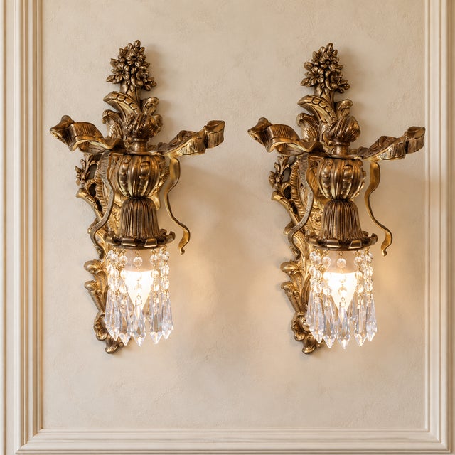 Elevate your walls with this striking pair of French-style crystal wall sconces, featuring beautifully sculpted bronze...